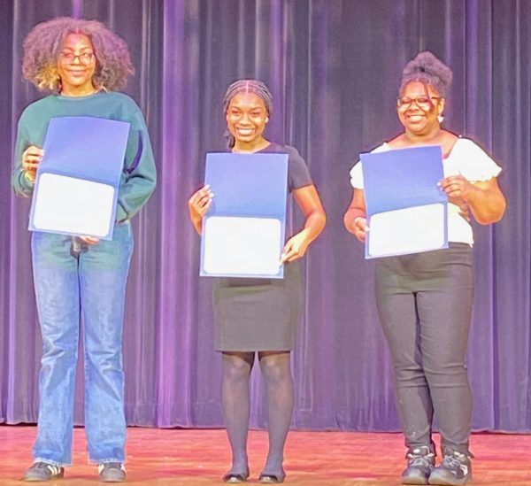 Tenth grade student, Nyla Dinkins (center), competed at the D.C. Poetry Out Loud competition on March 16. She won. On the right and left are the other top performers.